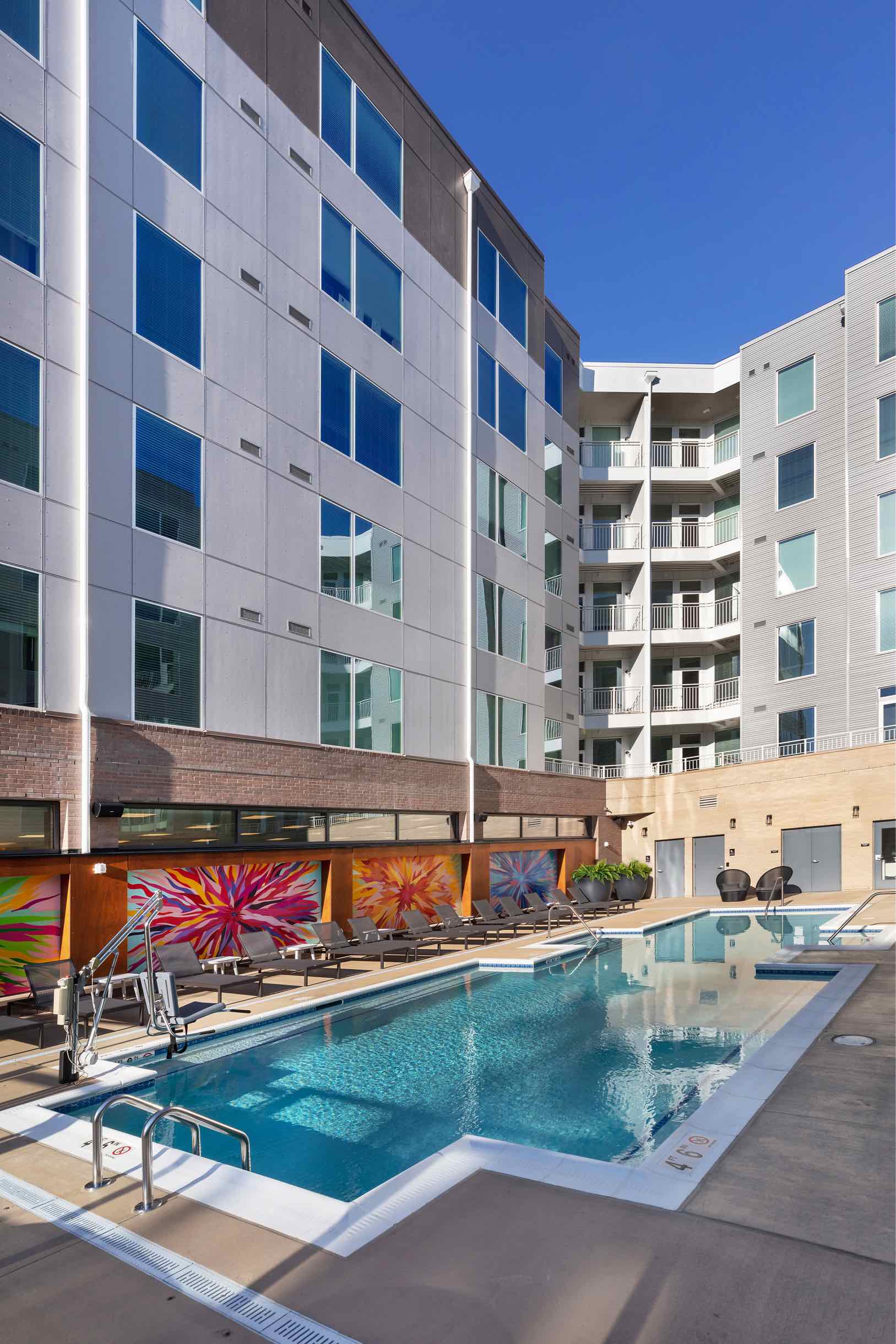 Resort style pool with mural and outdoor lounge